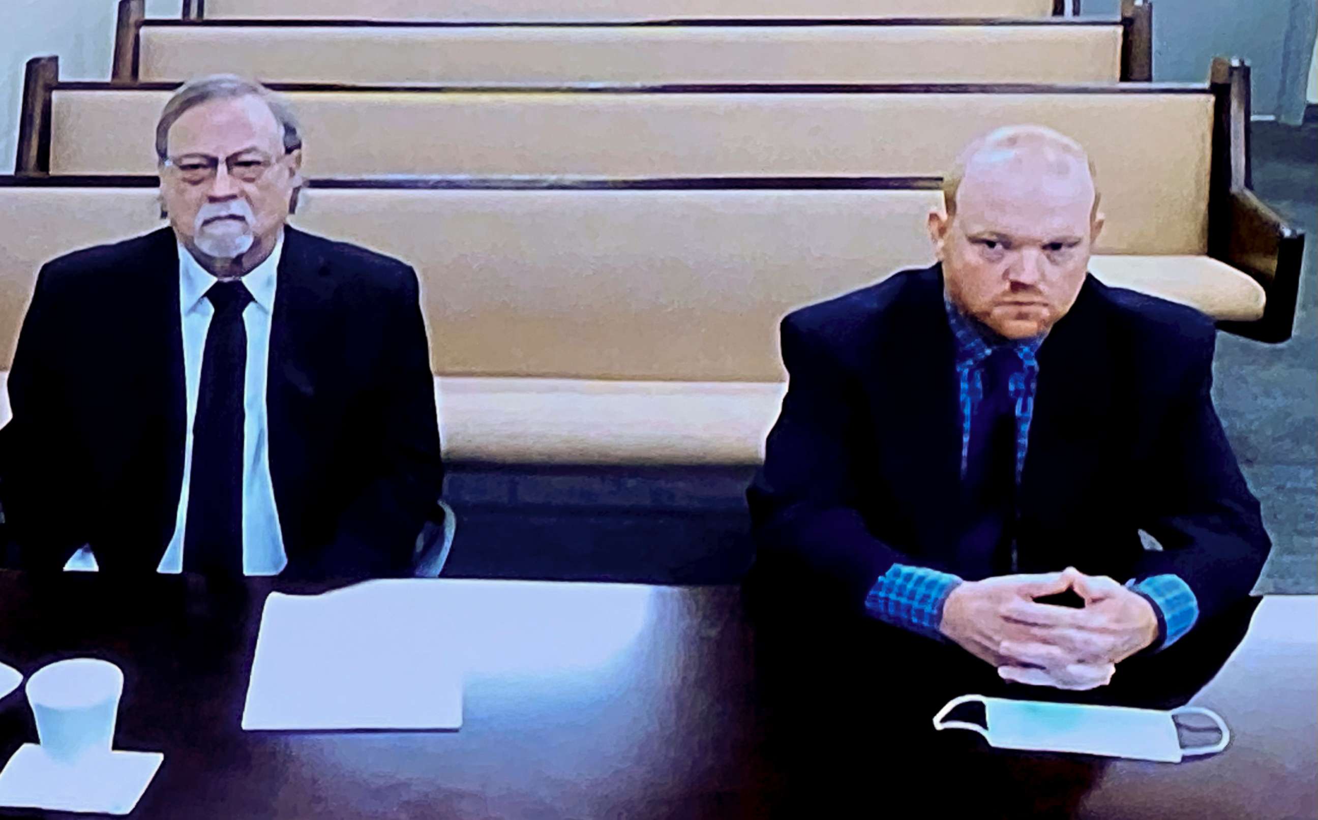 PHOTO: In this image made from video, from left, Gregory and Travis McMichael listen via closed circuit tv in the Glynn County Detention center in Brunswick, Ga., Nov. 12, 2020, as lawyers argue for bond to be set at the Glynn County courthouse.