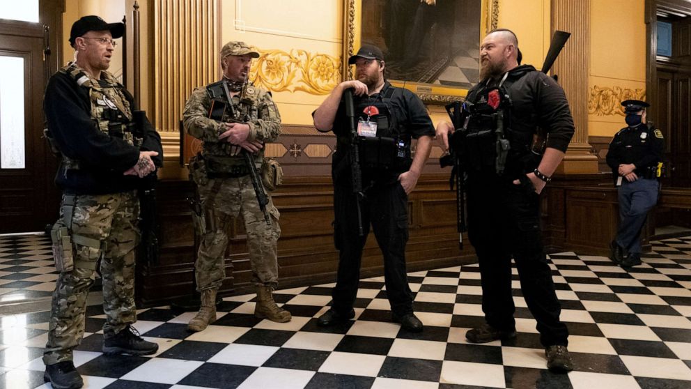 PHOTO: Members of a militia group stand near the doors to the chamber in the capitol building in Lansing, Mich., April 30, 2020.
