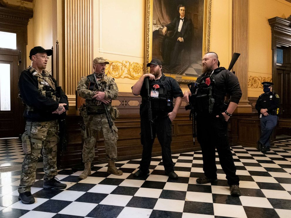 PHOTO: Members of a militia group stand near the doors to the chamber in the capitol building in Lansing, Mich., April 30, 2020.