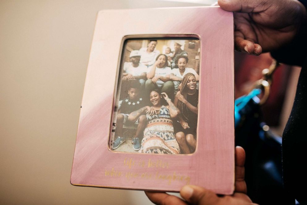 PHOTO: Valerie Griffin holds a up a family photo with her daughter, De'Janay Stanton, far right in braids, Nov. 19, 2021, at her home in Chicago.