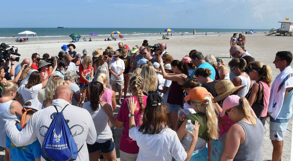 PHOTO: A group of supporters gathered with Stephanie Young McCluney, wife of Brian McCluney, one of two missing boaters, at Jetty Park, Port Canaveral, Fla., Aug. 18, 2019, to pray and search the shore for clues.