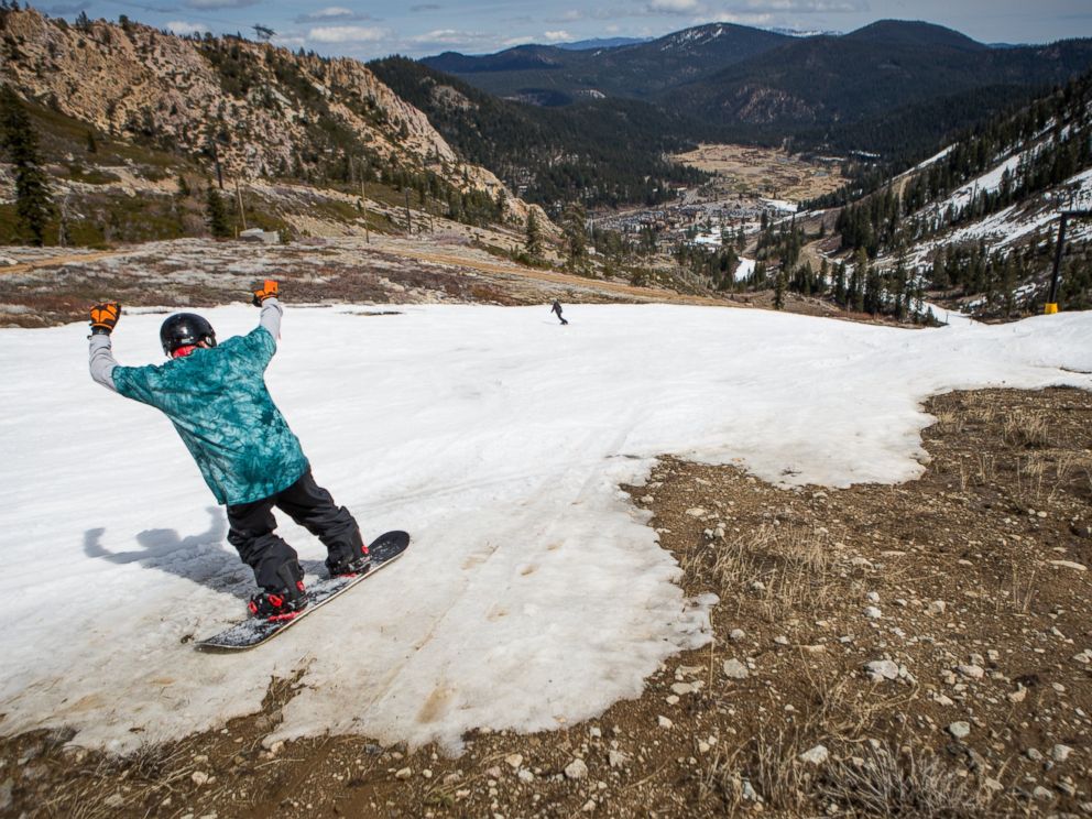 PHOTO: A snowboarder threads his way through patches of dirt at Squaw Valley Ski Resort, March 21, 2015 in Olympic Valley, Calif.