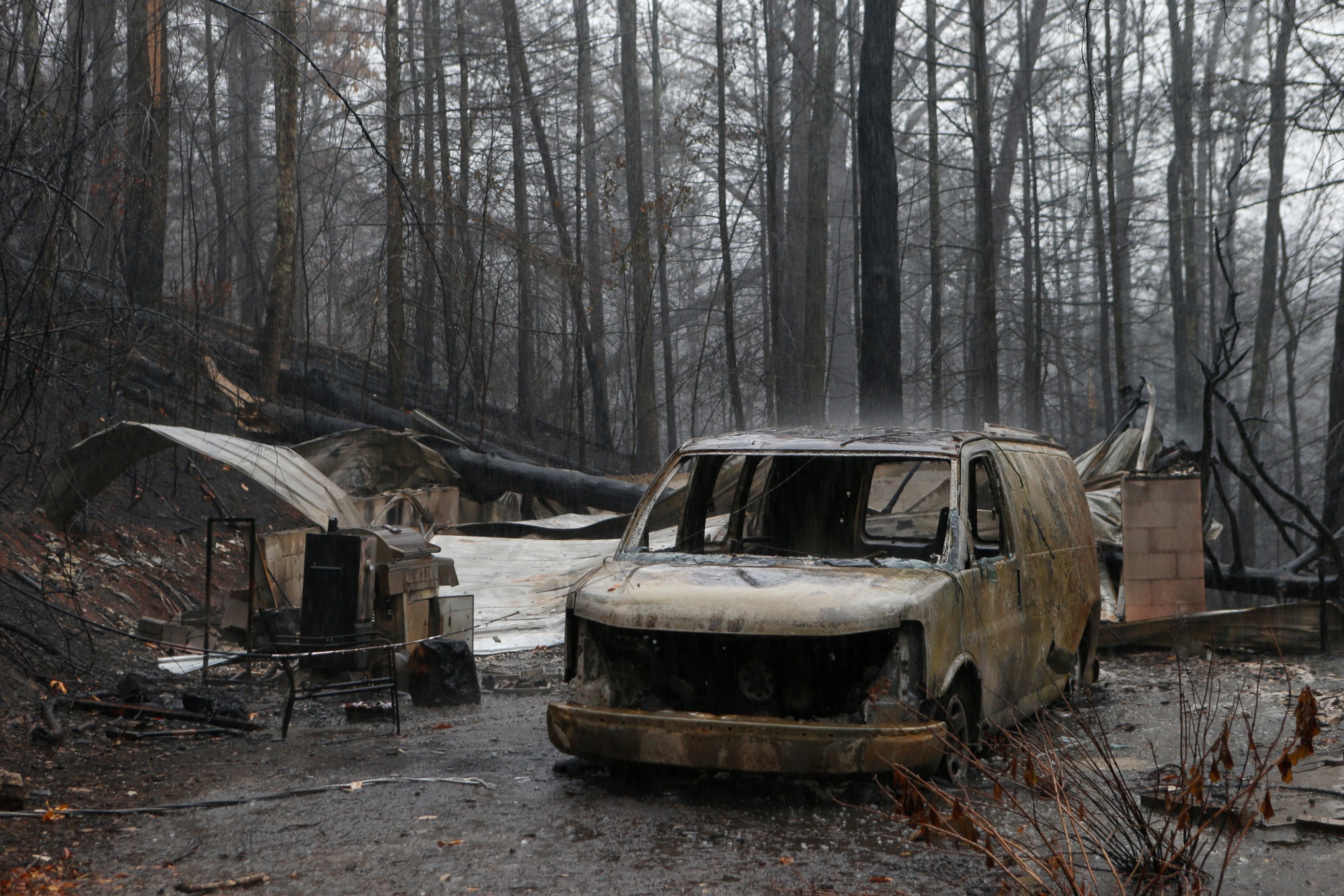 PHOTO: The remains of a van and home smolder in the wake of a wildfire, Nov. 30, 2016 in Gatlinburg, Tennessee. 