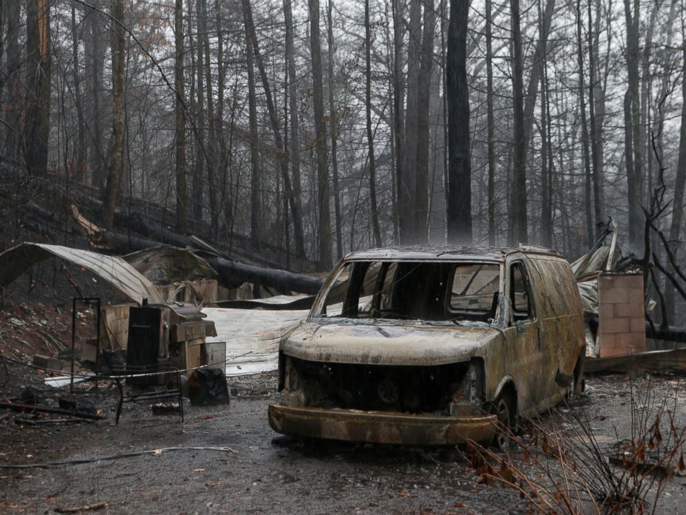 PHOTO: The remains of a van and home smolder in the wake of a wildfire, Nov. 30, 2016 in Gatlinburg, Tennessee.