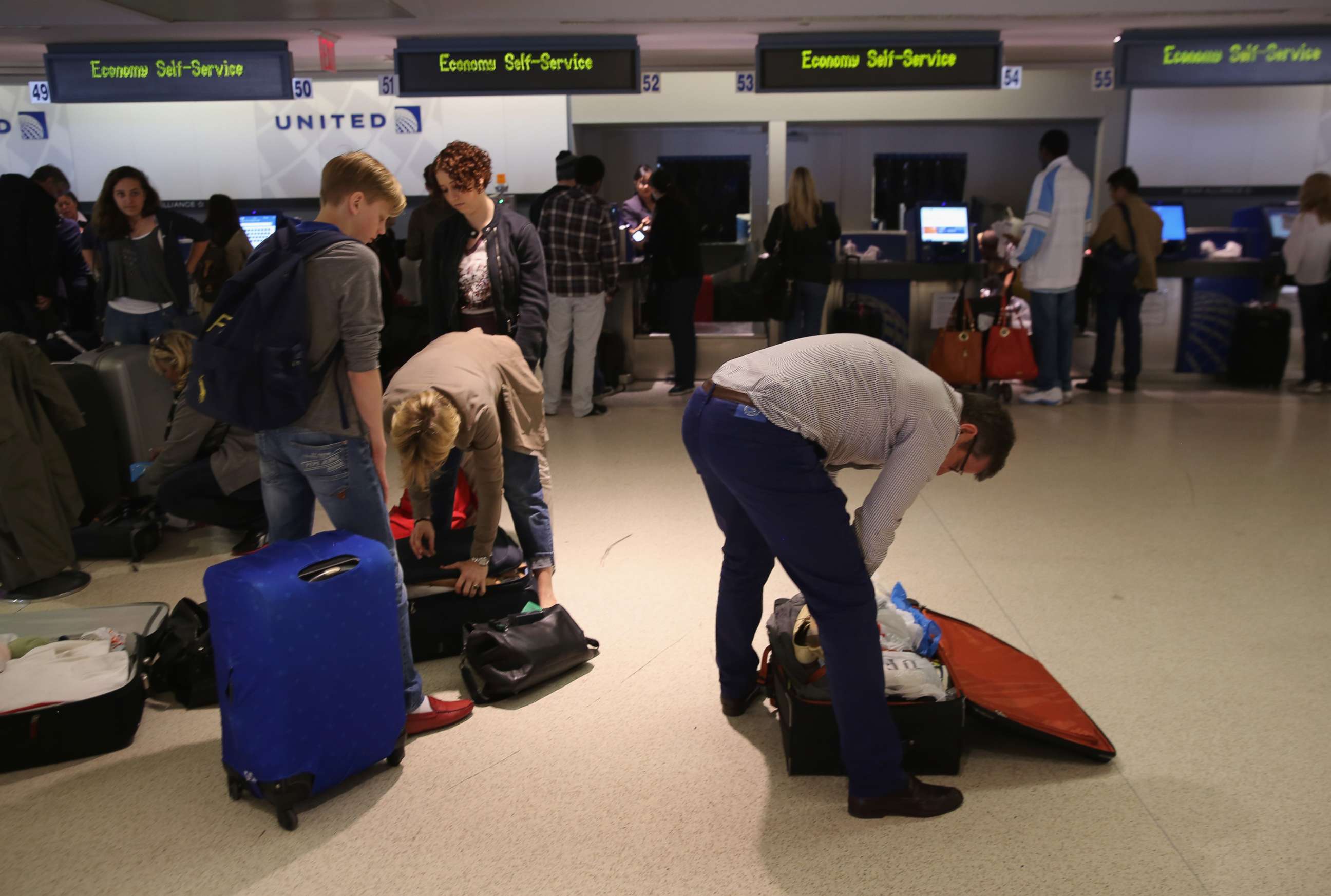 Passengers repack luggage before it is screened at a new explosives detection system at the Newark Liberty International Airport on May 1, 2014. 
