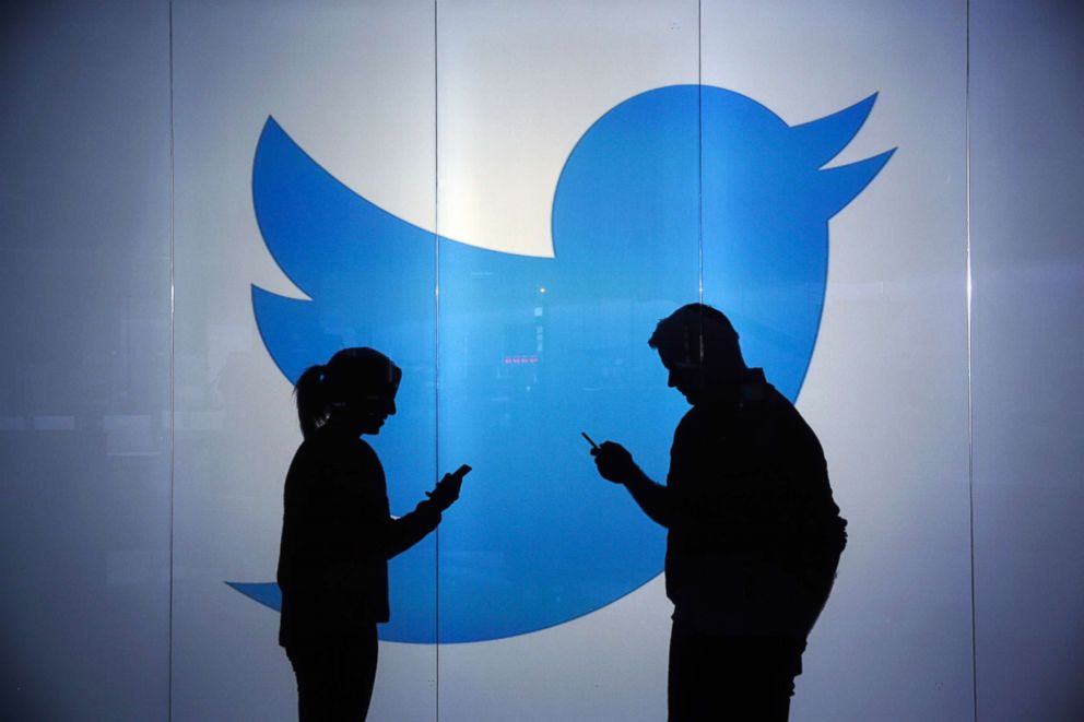 PHOTO: People stand in front of a Twitter logo in a stock photo, Jan. 5, 2016.
