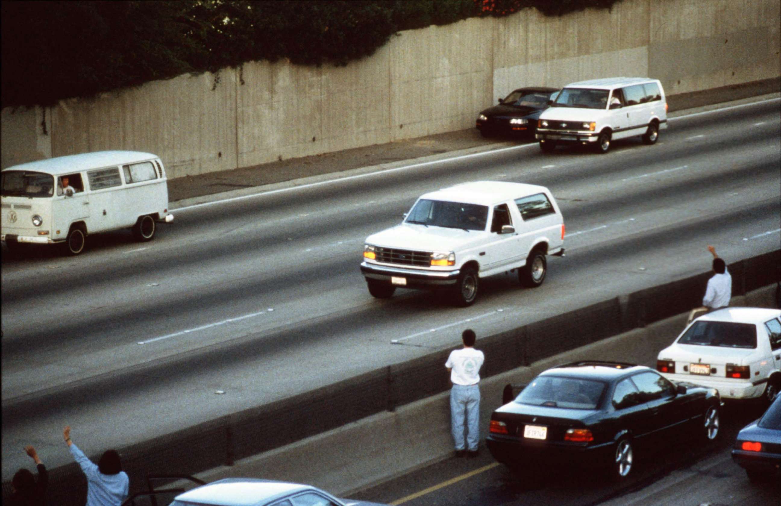 PHOTO: Motorists wave as police cars pursue the Ford Bronco carrying fugitive murder suspect O.J. Simpson on a 90-minute slow-speed car chase June 17, 1994 on the 405 freeway in Los Angeles, Calif.