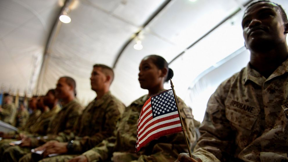 A U.S. soldier holds an American flag as he and others attend a naturalization ceremony at the U.S. base in Bagram, Afghanistan on July 4, 2013.