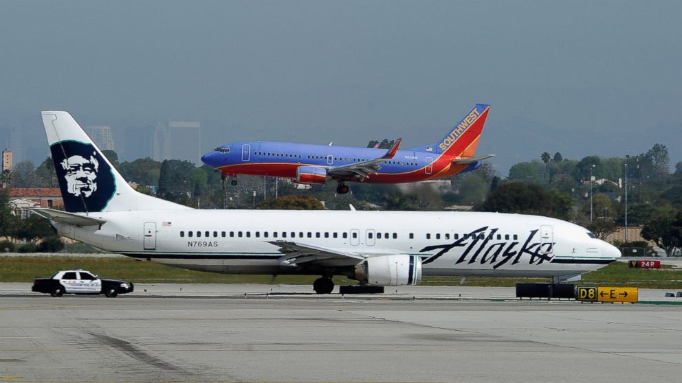 A Southwest Airlines Boeing 737 passenger jet lands as an Alaska Air Boeing 737 jet prepares to take off at Los Angeles International Airport on April 5, 2011.
