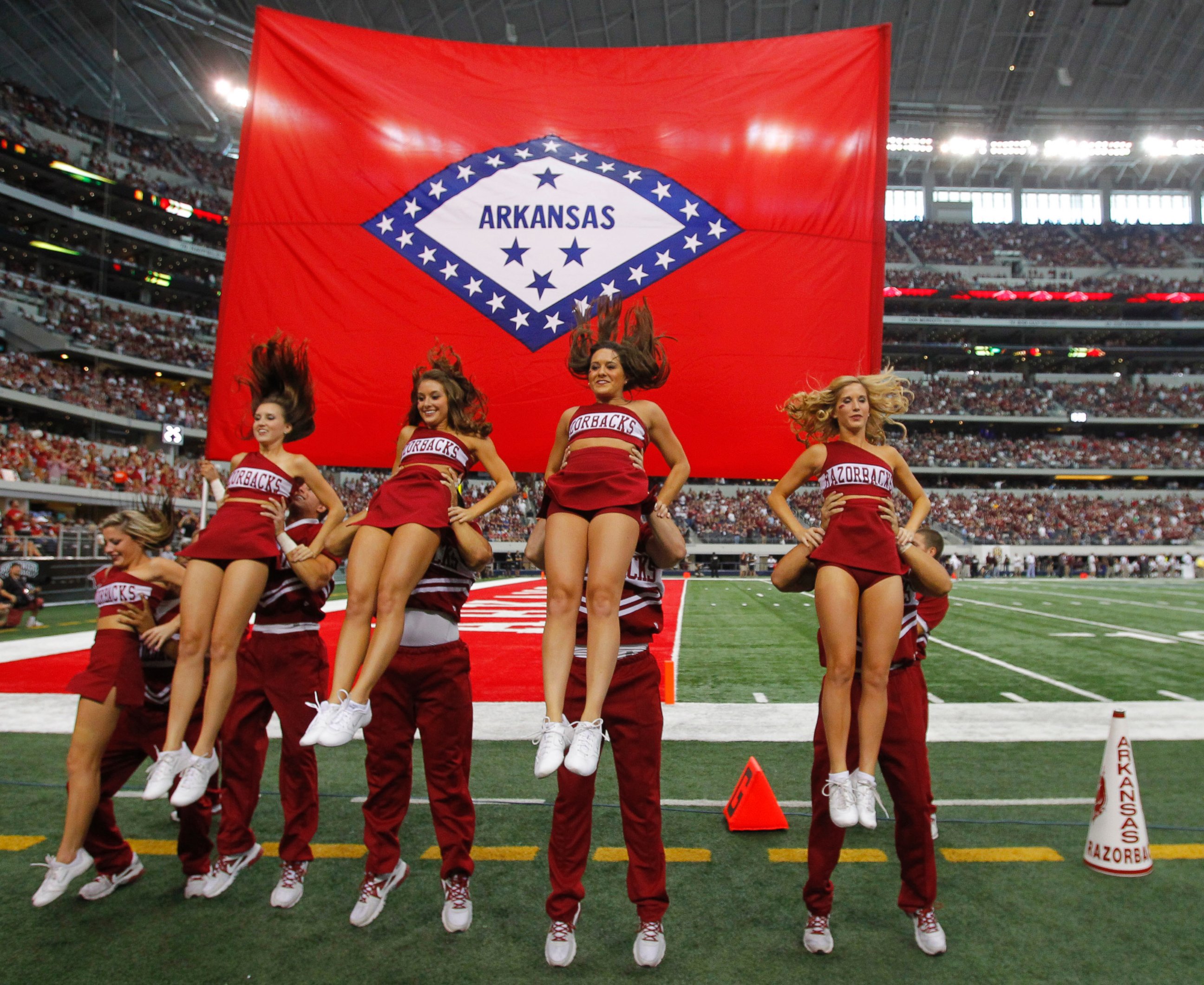 PHOTO: Arkansas cheerleaders perform a routine in front of their state flag at Cowboys Stadium in Arlington, Texas, on Oct. 1, 2011. 