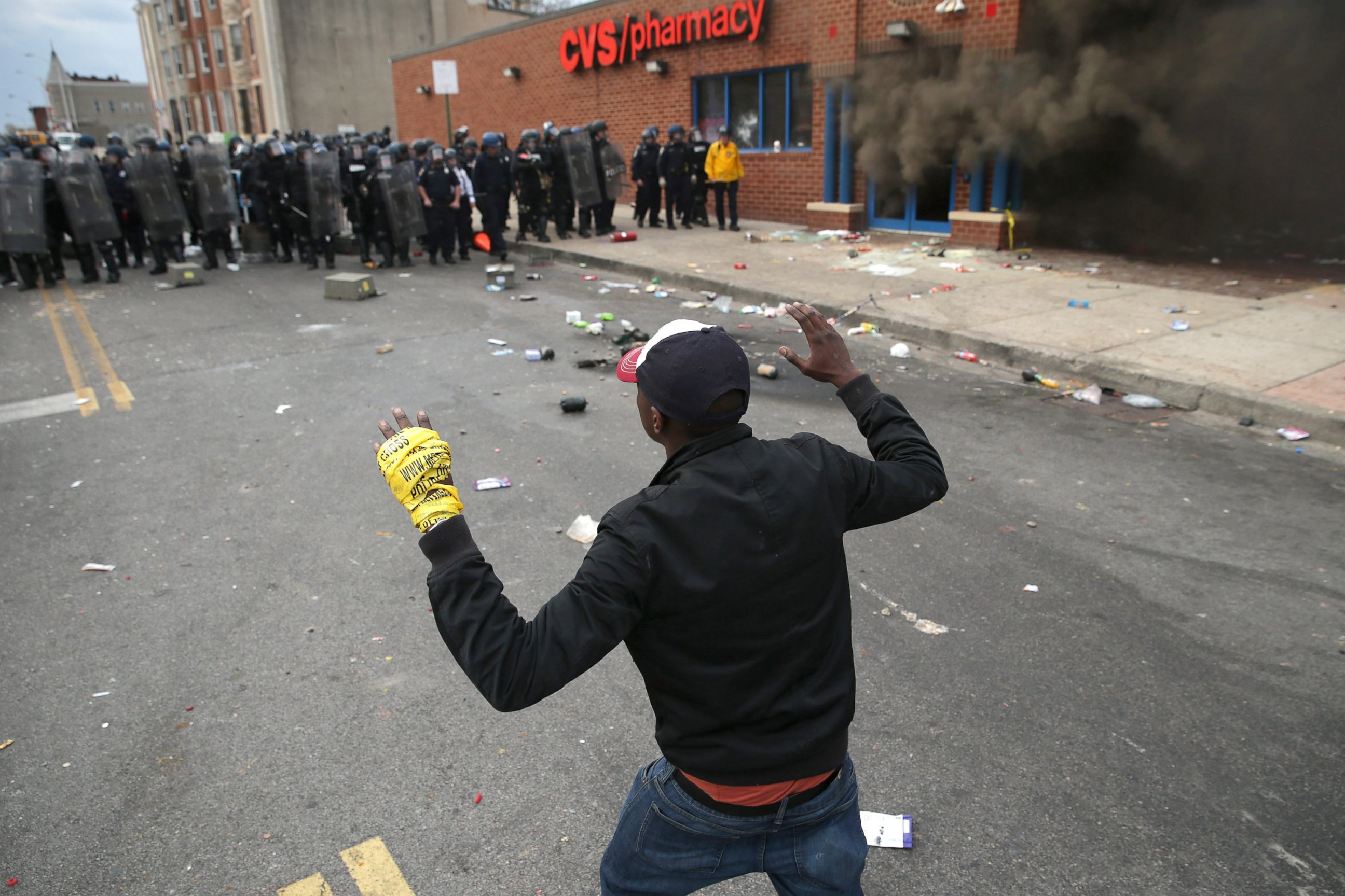 PHOTO: A man faces down a line of Baltimore Police as a CVS burns during violent protests following the funeral of Freddie Gray, April 27, 2015 in Baltimore. 