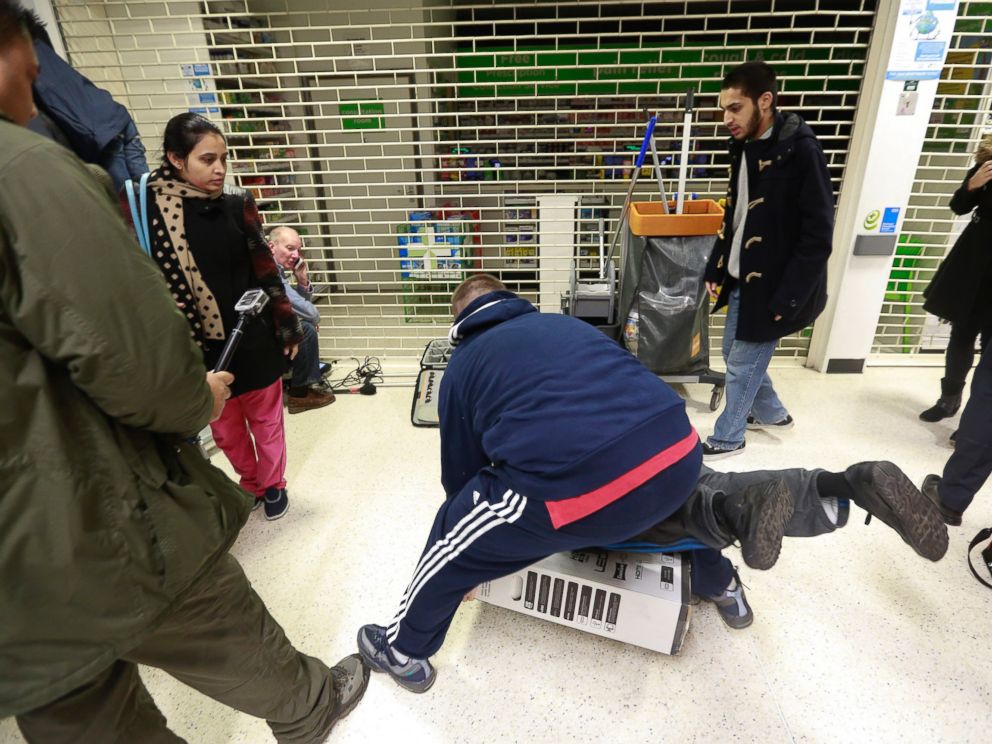 PHOTO: Customers fall to the floor as they grapple for an LED television during a Black Friday discount sale at an Asda supermarket in London on Nov. 28, 2014.