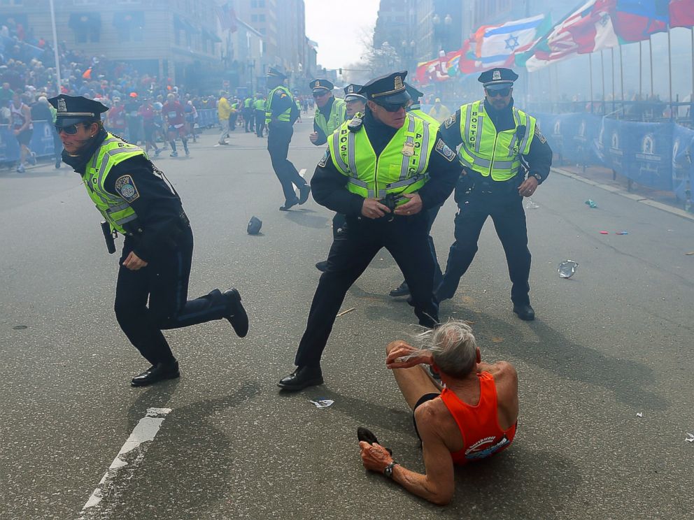 PHOTO: A runner is on the ground as police officers draw their guns after the second explosion near the finish line of the 117th Boston Marathon, April 15, 2013.