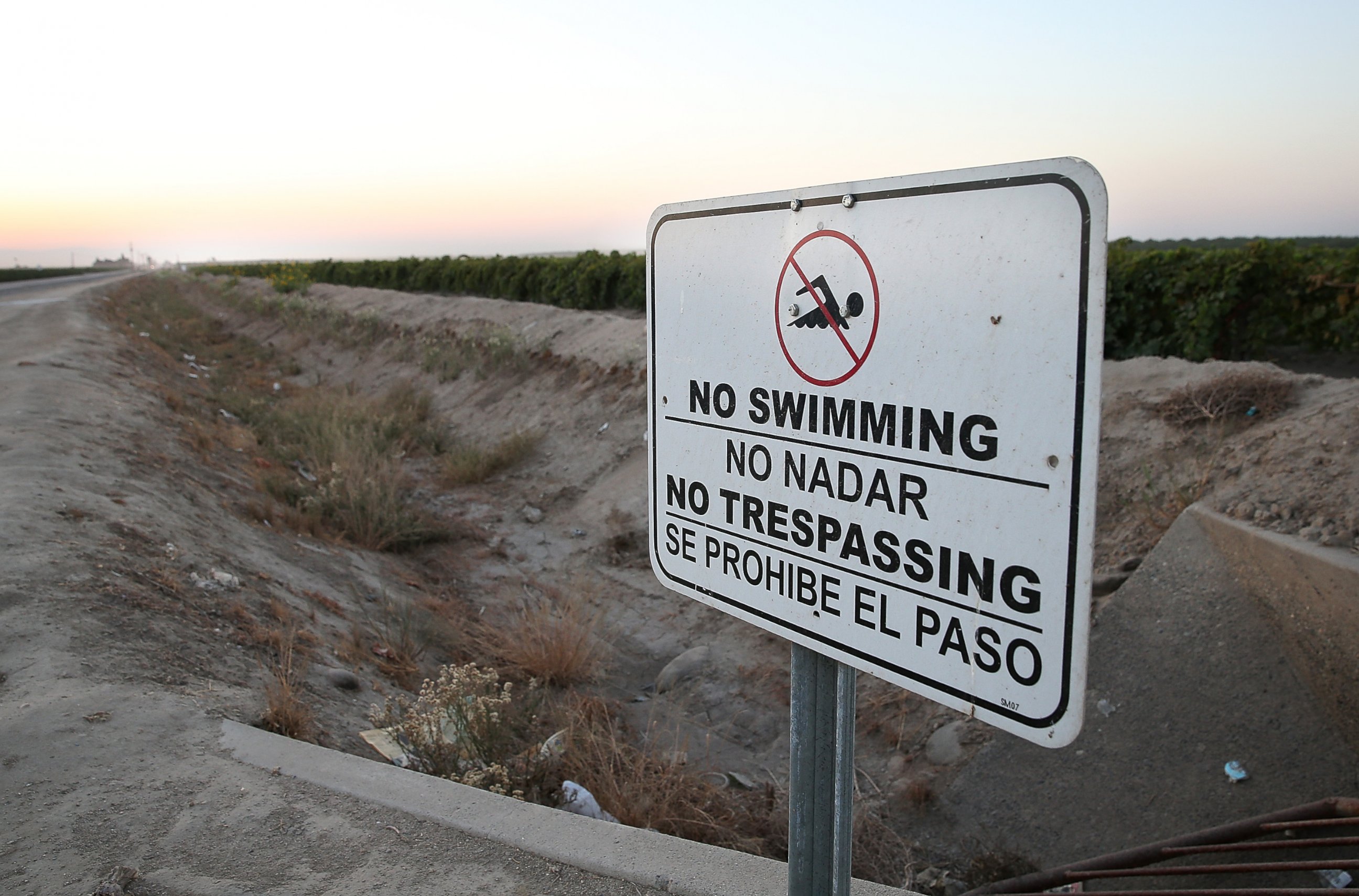 PHOTO: A "no swimming" sign is posted next to a dry irrigation canal on August 22, 2014 in Madera, California. 