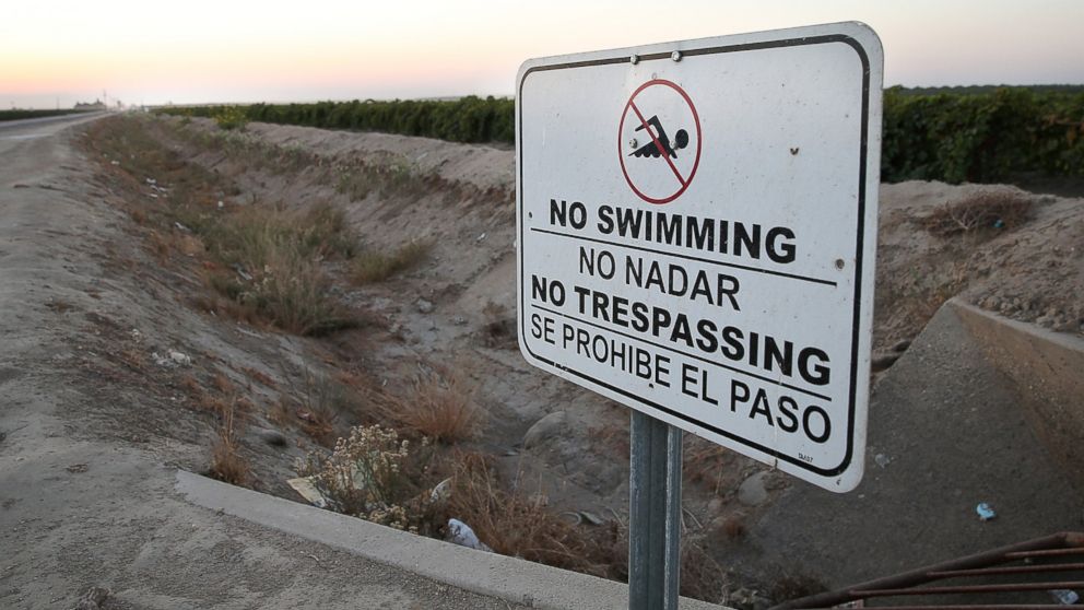 PHOTO: A "no swimming" sign is posted next to a dry irrigation canal on August 22, 2014 in Madera, California. 
