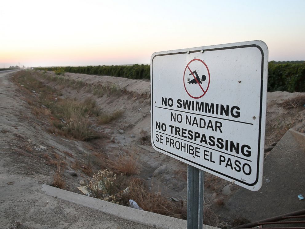 PHOTO: A no swimming sign is posted next to a dry irrigation canal on August 22, 2014 in Madera, California.