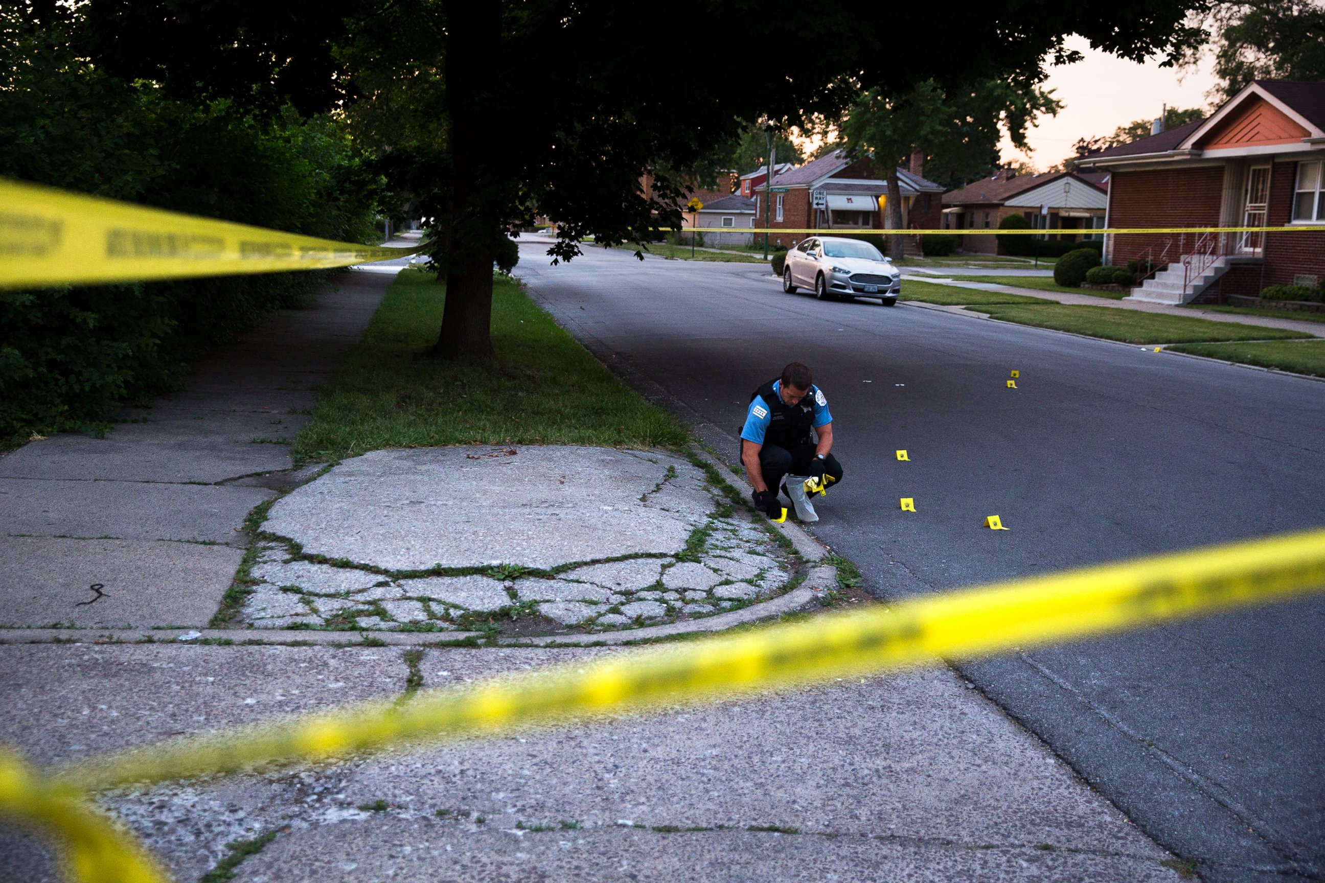 PHOTO: A member of the Chicago Police Department collects bullet casings at the scene of a shooting near the intersection of South Morgan Street and West 97th Street in Chicago on July 3, 2016.