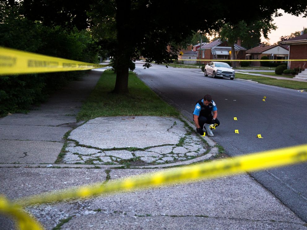 PHOTO: A member of the Chicago Police Department collects bullet casings at the scene of a shooting near the intersection of South Morgan Street and West 97th Street in Chicago on July 3, 2016.
