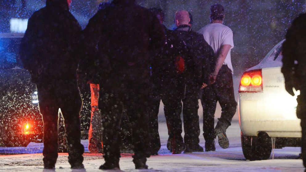 Police escort a shooting suspect out of an armored vehicle at the intersection of Centennial and Fillmore on Nov. 27, 2015, in Colorado Springs, Colorado.