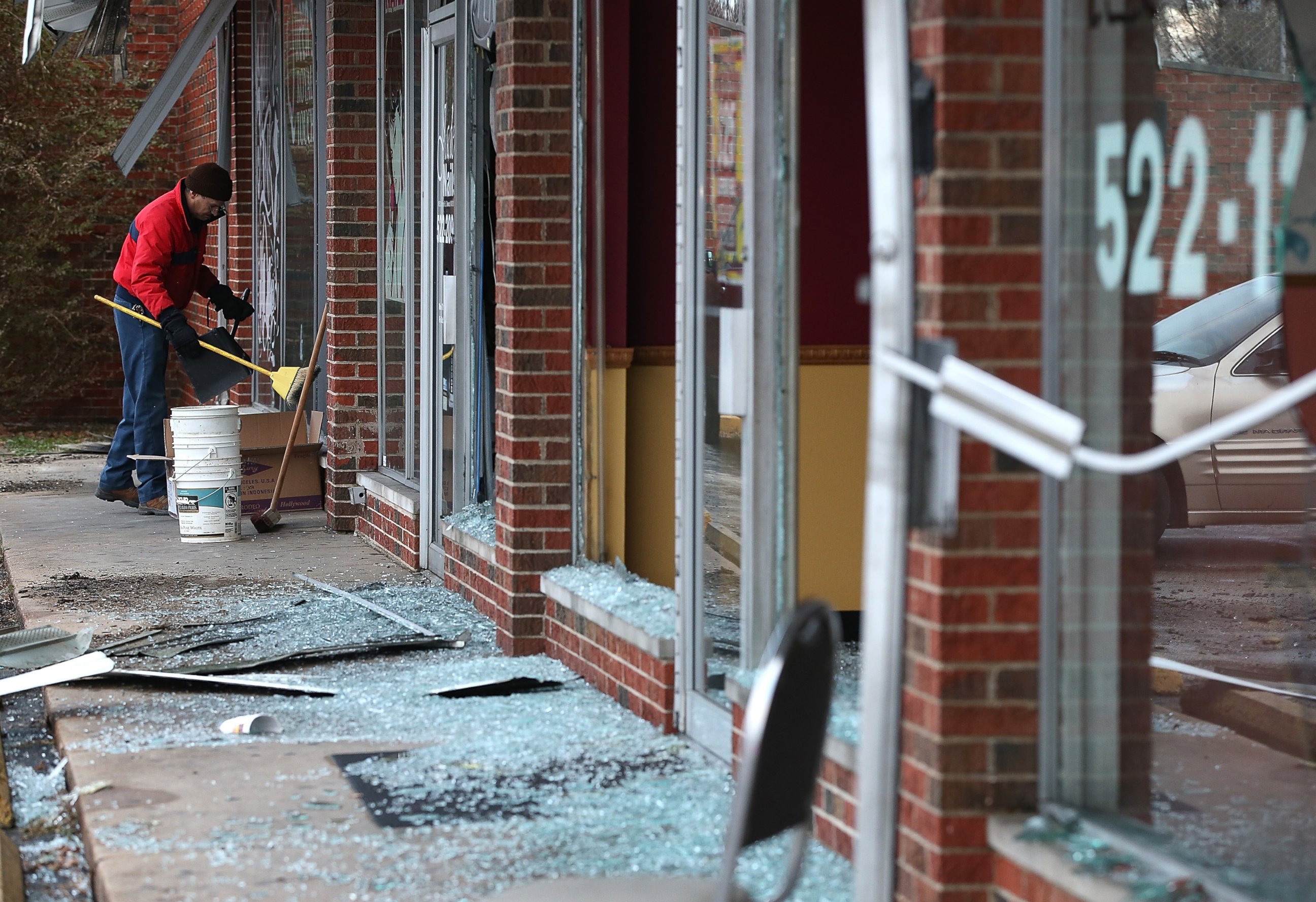 PHOTO: A worker cleans up glass at a building that was damaged during a demonstration on Nov. 25, 2014 in Dellwood, Mo. 