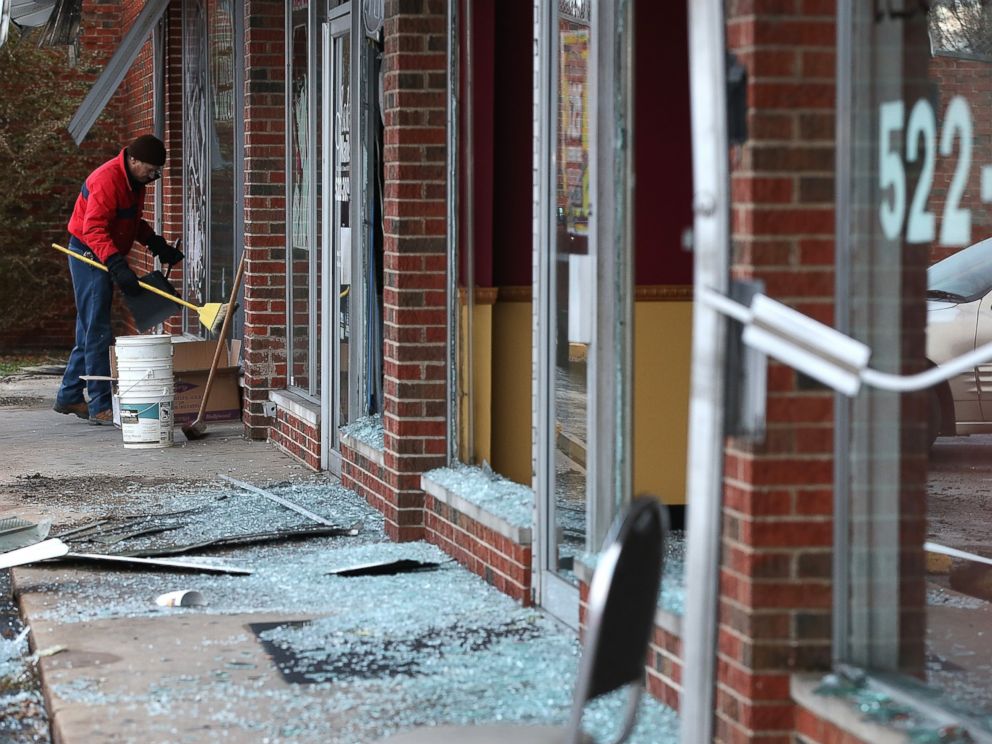 PHOTO: A worker cleans up glass at a building that was damaged during a demonstration on Nov. 25, 2014 in Dellwood, Mo.