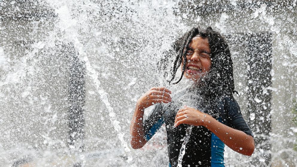 PHOTO: A Camp Vibrant camper cools off in the Christian Science Center fountain in Boston, Massachusetts, July 25, 2016.
