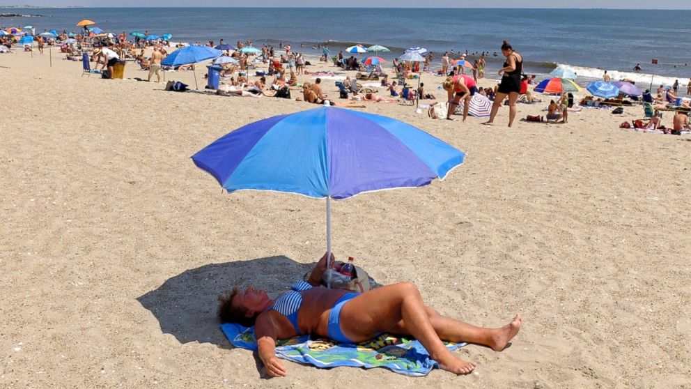 A woman sunbathes at Rockaway Beach, July 26, 2016, in New York. A heat wave continues with temperatures expected to stay in the 90's across most of the Eastern U.S until this weekend. 