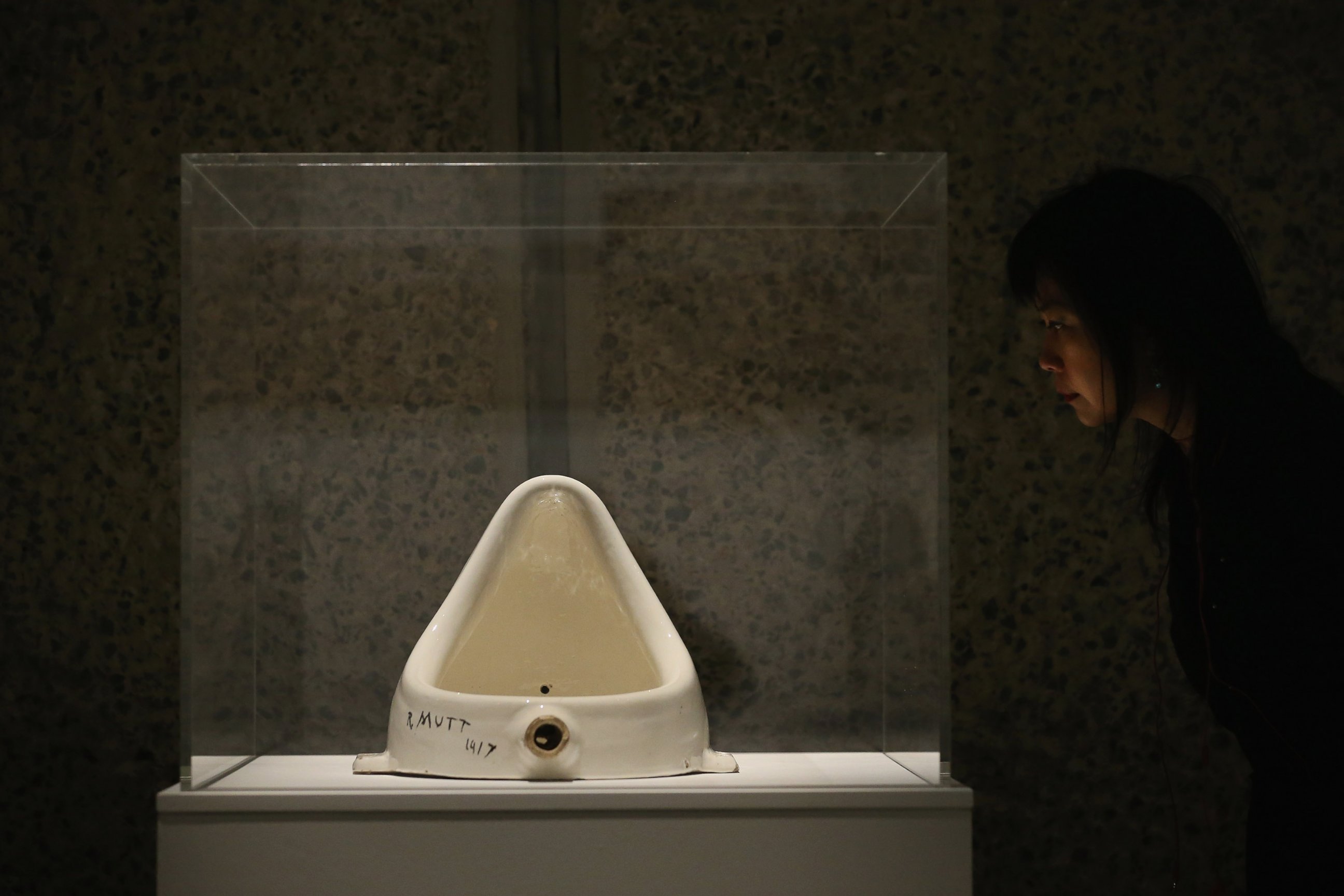 PHOTO: A woman looks at "Fountain" by Marcel Duchamp during a press preview of an exhibition at the Barbican Art Gallery on Feb. 13, 2013 in London.
