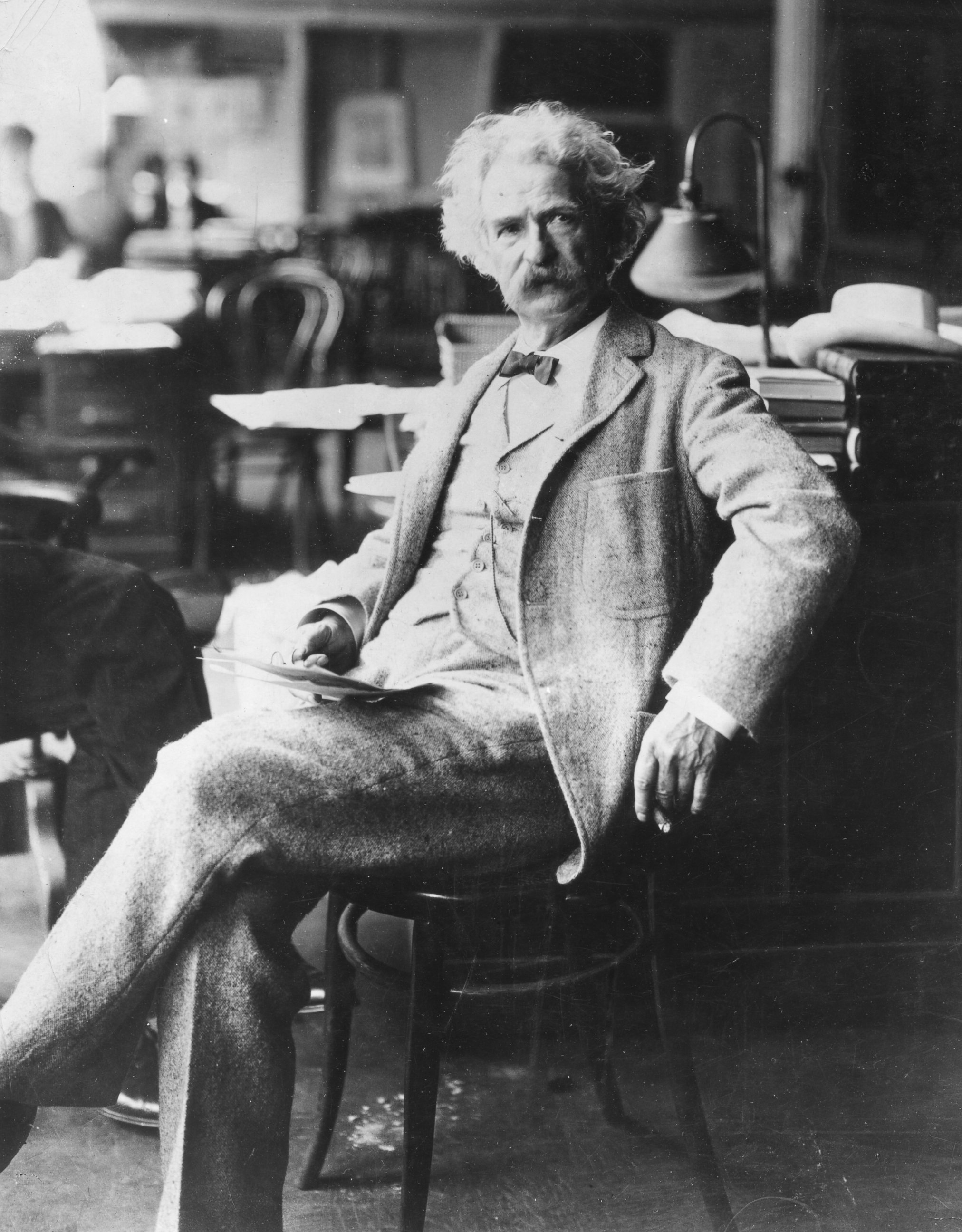 PHOTO: Portrait of American author Samuel Clemens, better known as Mark Twain, as he sits in a chair, late 19th century.