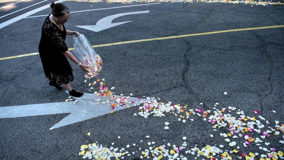 PHOTO: A woman places flower petals along the entrance to Cave Hill Cemetery for the funeral procession for boxing legend Muhammad Ali on June 10, 2016 in Louisville, Kentucky.