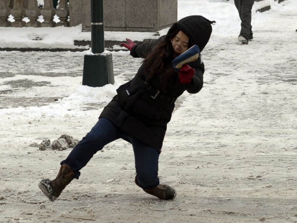 PHOTO: A woman falls on the ice and snow along 5th Avenue on Jan. 22, 2014 in New York.
