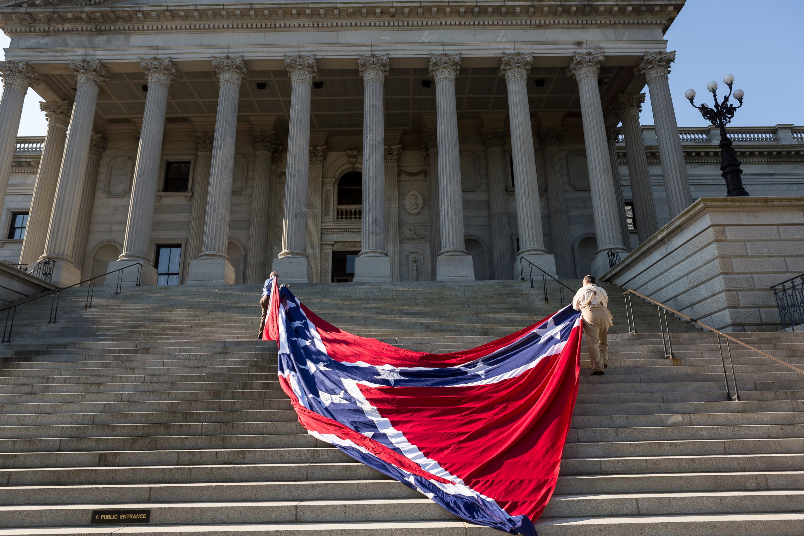 PHOTO: Confederate re-enactors position a gigantic Confederate flag on the steps of the South Carolina State Capitol building on May 2, 2015 in Columbia, SC. 