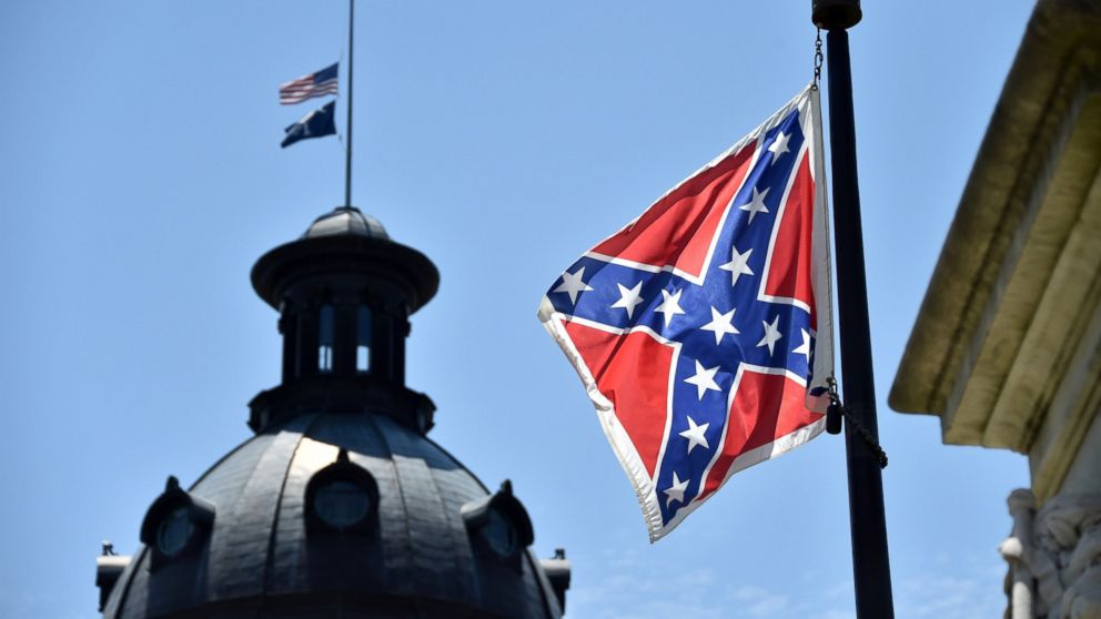 PHOTO: The South Carolina and American flags flying at half-staff behind the Confederate flag erected in front of the State Congress building in Columbia, South Carolina on June 19, 2015. 