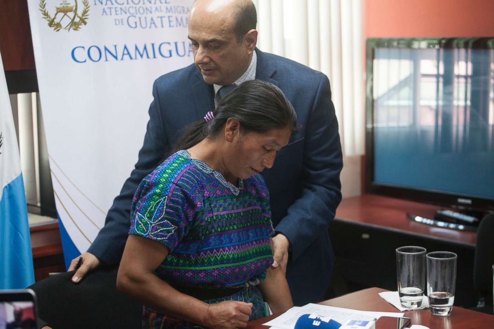PHOTO: Dominga Vicente, front, is comforted by the National Migrants Commissioner Carlos Nares during a press conference in Guatemala City, May 25, 2018.