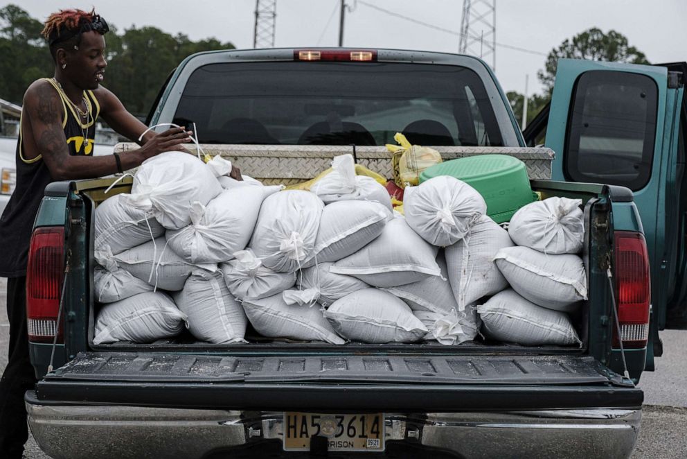 PHOTO: Daquan Hamis loads sandbags into the back of a truck as Hurricane Zeta approaches in Gulfport, Miss., Oct. 2020.
