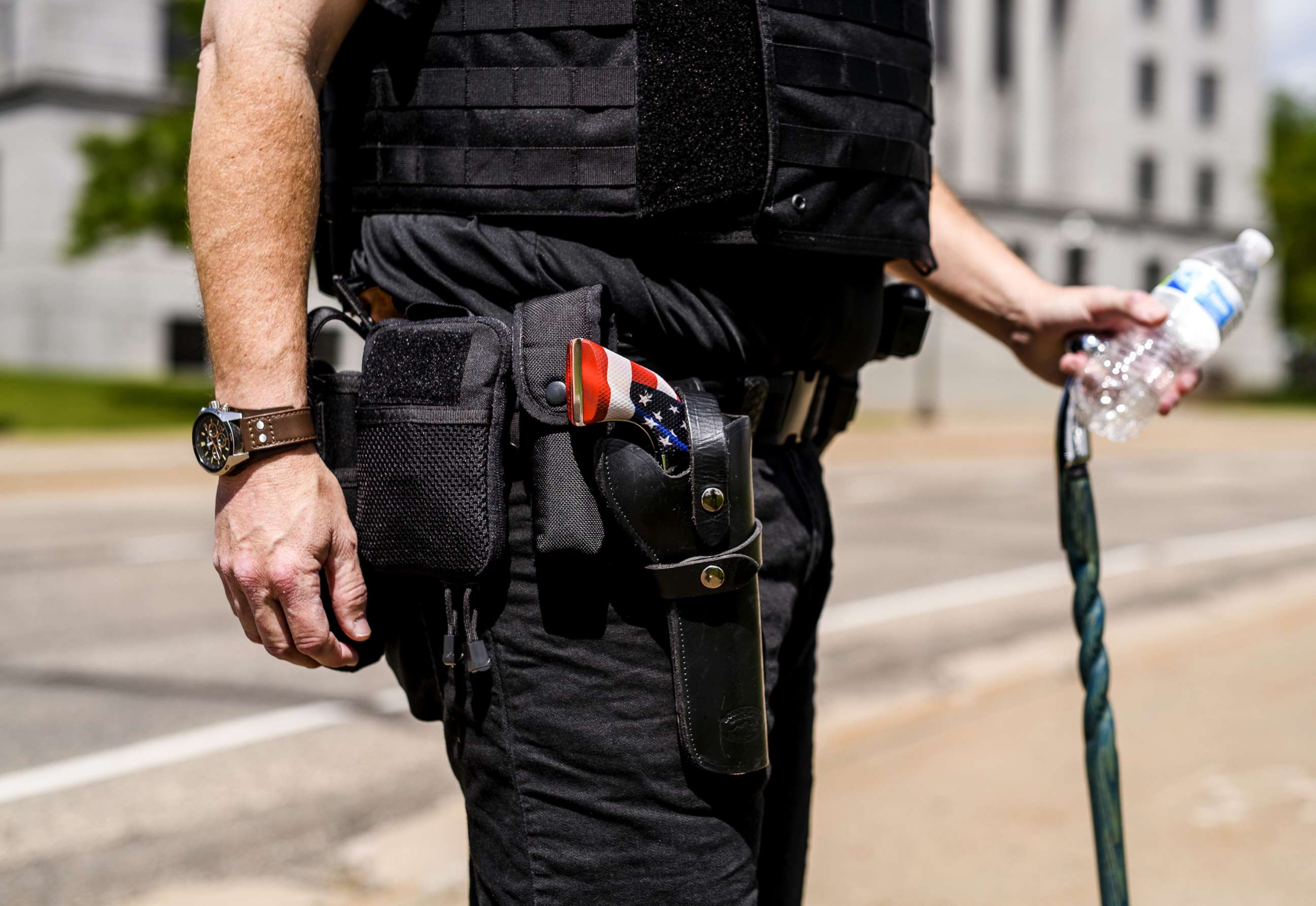 PHOTO: A man carries a revolver with an American Flag decor outside the Minnesota State Capitol building, May 22, 2021, in St. Paul, Minn.