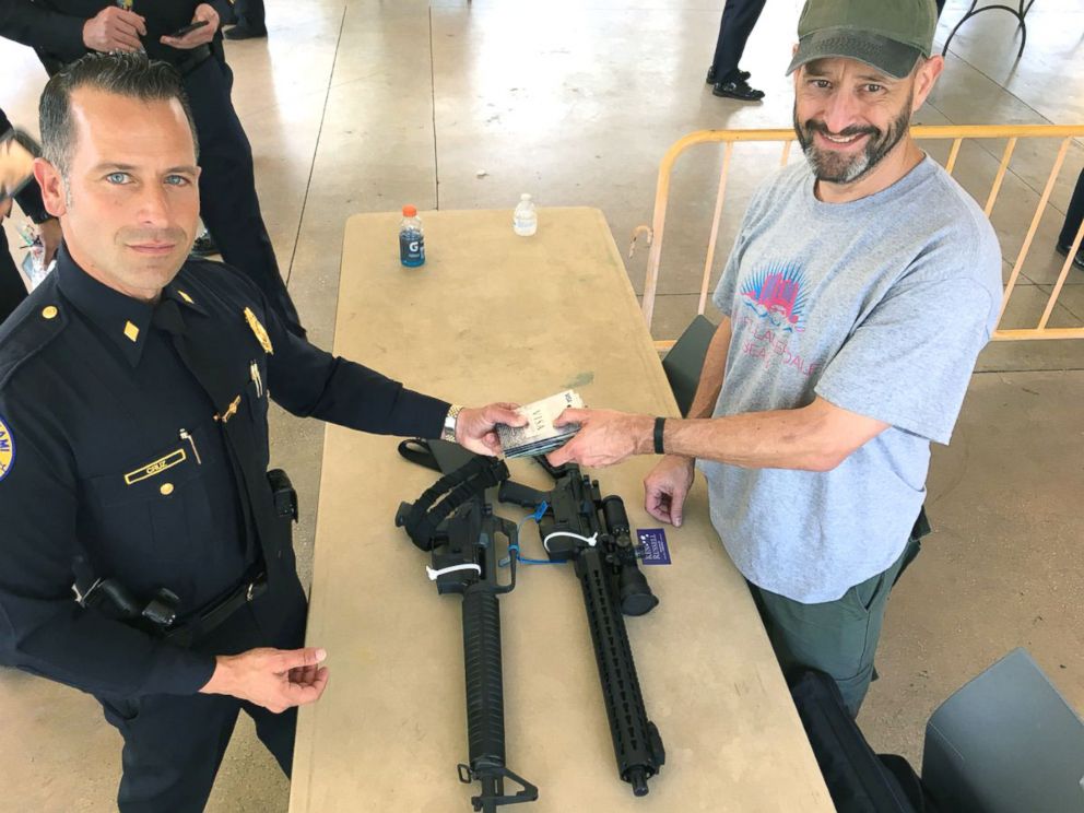 PHOTO: Steve Hemmert (right) is pictured at the Miami Police Department’s gun buyback event, March 17, 2018. 