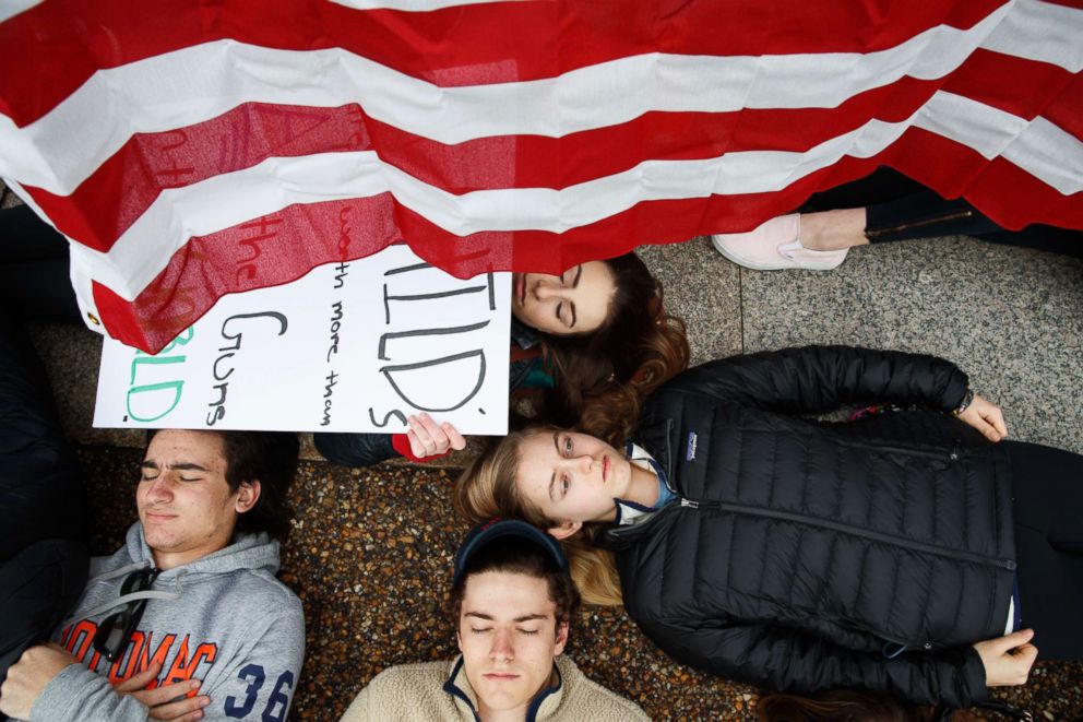 PHOTO: Anna Hurley, 15, of Washington, top, and other demonstrators participate in a "lie-in" during a protest in favor of gun control reform in front of the White House in Washington, D.C., Feb. 19, 2018.