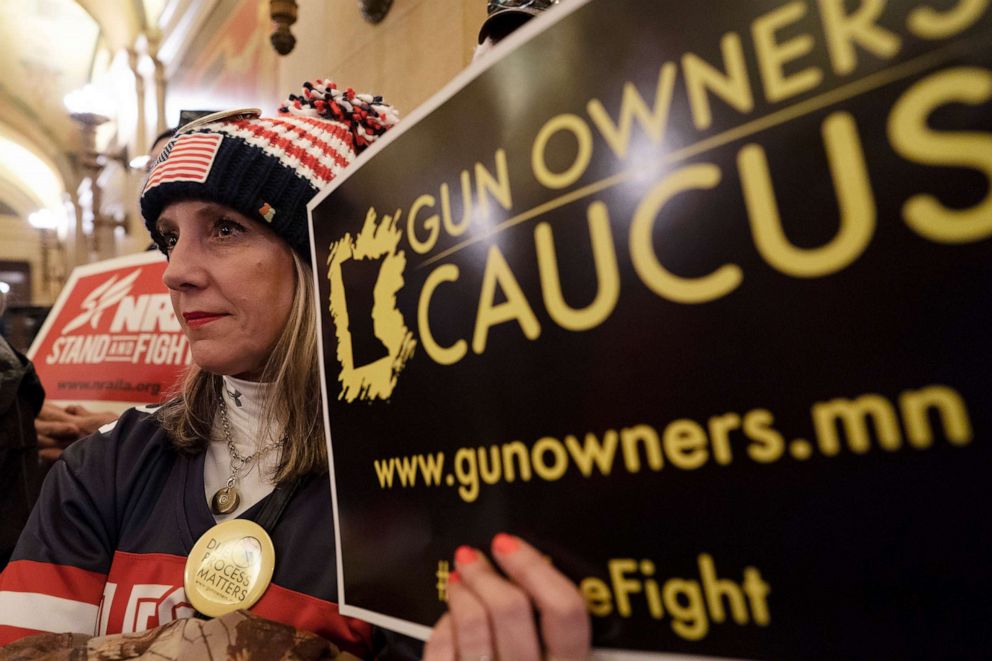 PHOTO: Jessica Kllingler holds a Gun Owners Caucus sign during the House public safety meeting about expanding background checks, at the State Capitol in St. Paul, Minn., Feb. 27, 2019.