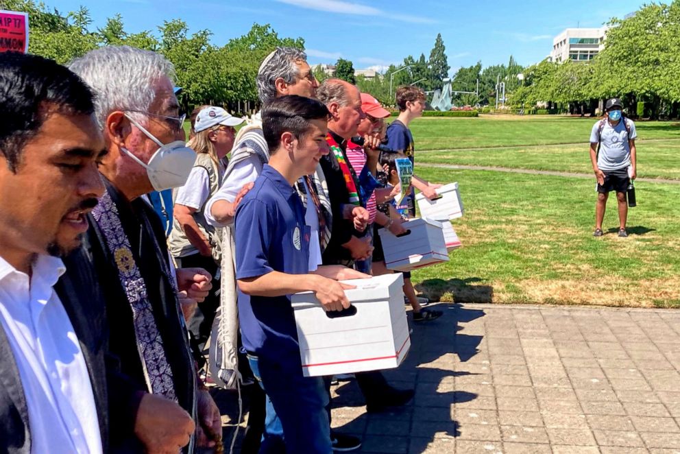 PHOTO: In this July 8, 2022, file photo, backers of a proposed initiative that would require people to secure permits to buy firearms and ban large-capacity magazines deliver the signatures of thousands of voters to state election offices in Salem, Ore.
