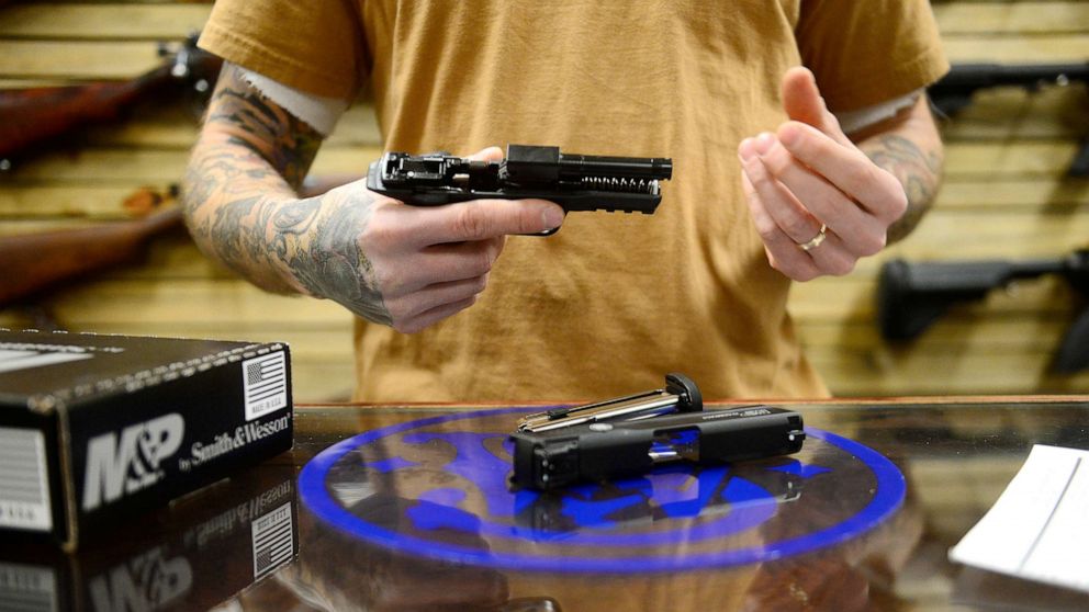 PHOTO: Ryan Resch disassembles a .22 caliber handgun at BigHorn Firearms on December 16, 2015 in Denver, Colorado.