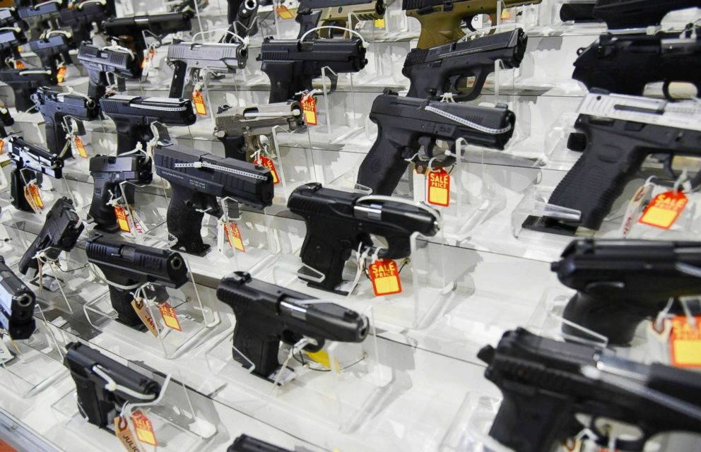 PHOTO: Guns lie in a booth during a gun show.