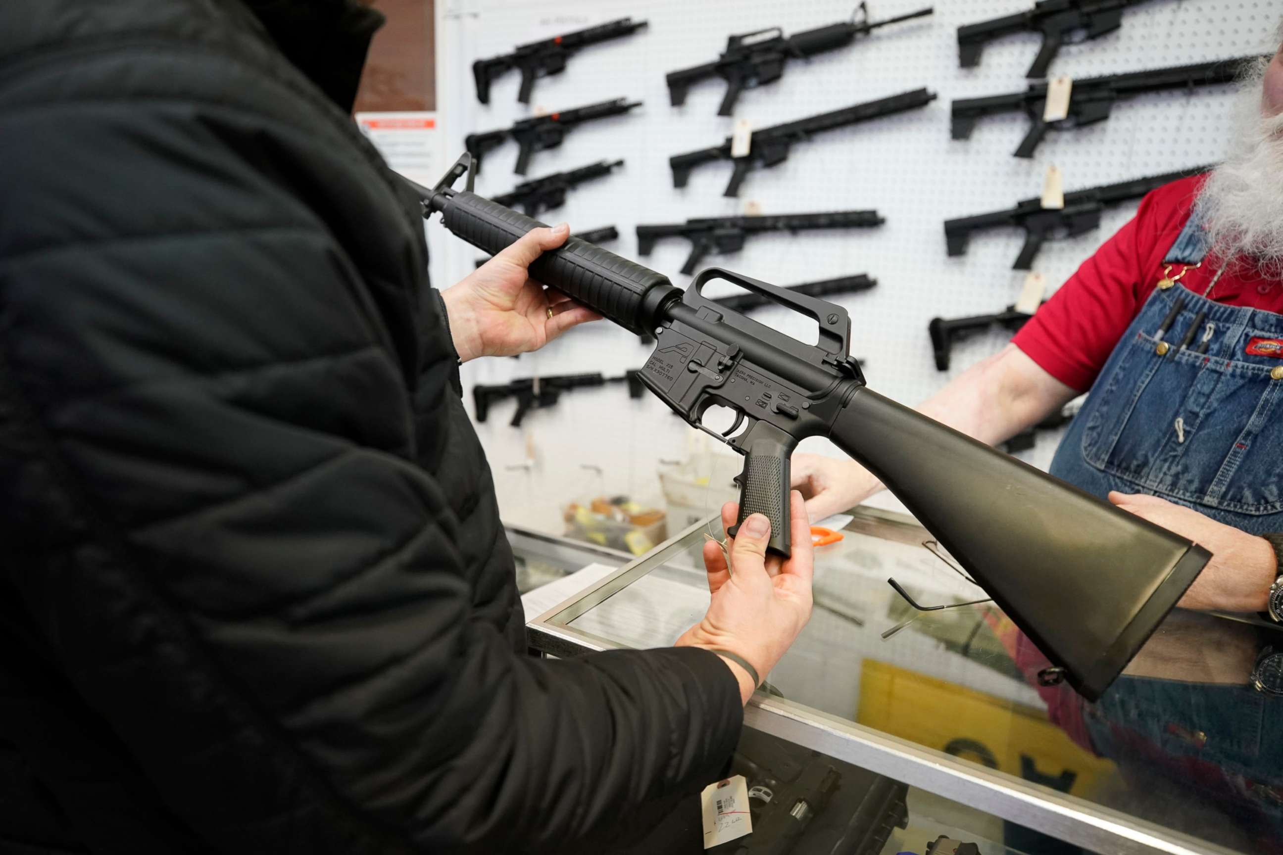 PHOTO: In this March 25, 2021, file photo, a salesperson shows an AR-15 rifle to a customer at a store in Orem, Utah.