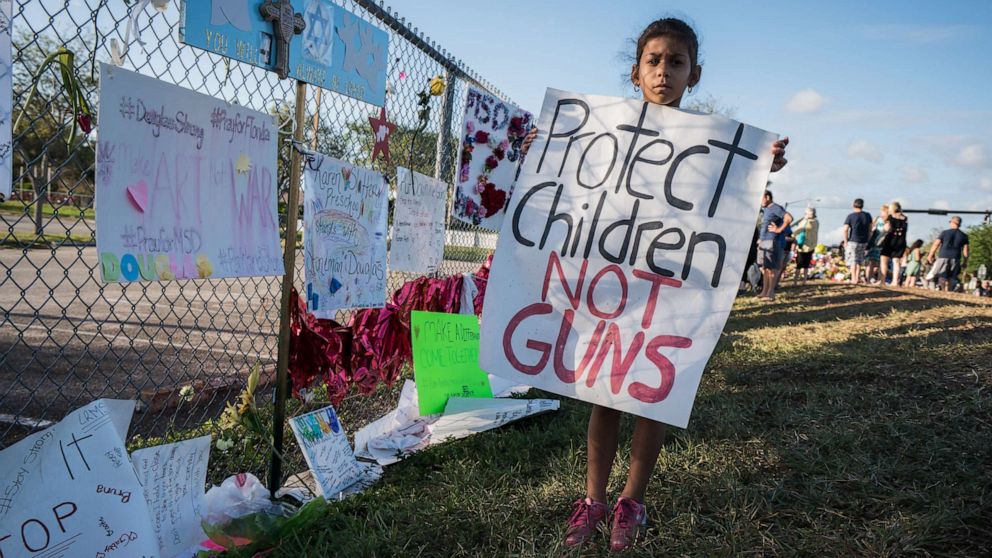 PHOTO: A young school child holds a sign 'Protect Children NOT Guns' at Stoneman Douglas High School, in Parkland, Fla., Feb. 25, 2018.
