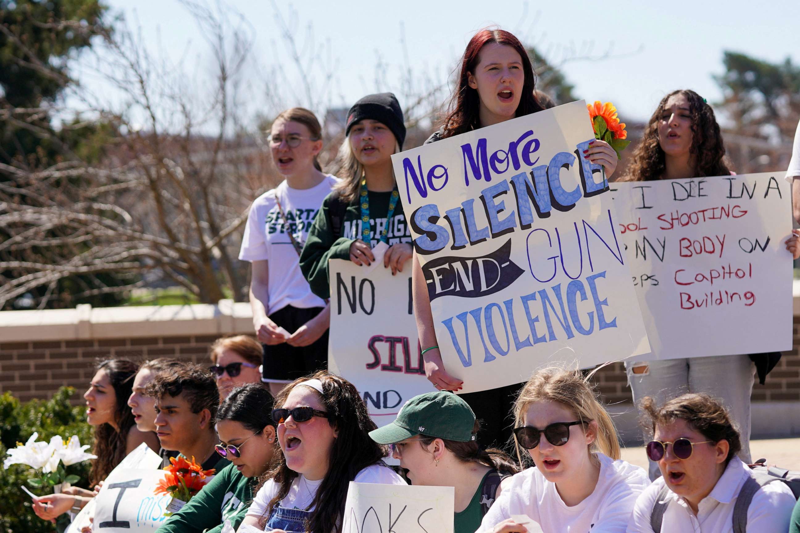 PHOTO: Students demonstrate next to the Spartan statue as they stand with others that have faced gun violence two months after a shooting at Michigan State University in East Lansing, Mich., April 12, 2023.