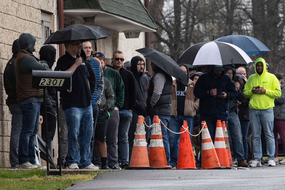 PHOTO: People wait in line to enter gun seller Tanner's Sports Center in Jamison, Pa., March 17, 2020.