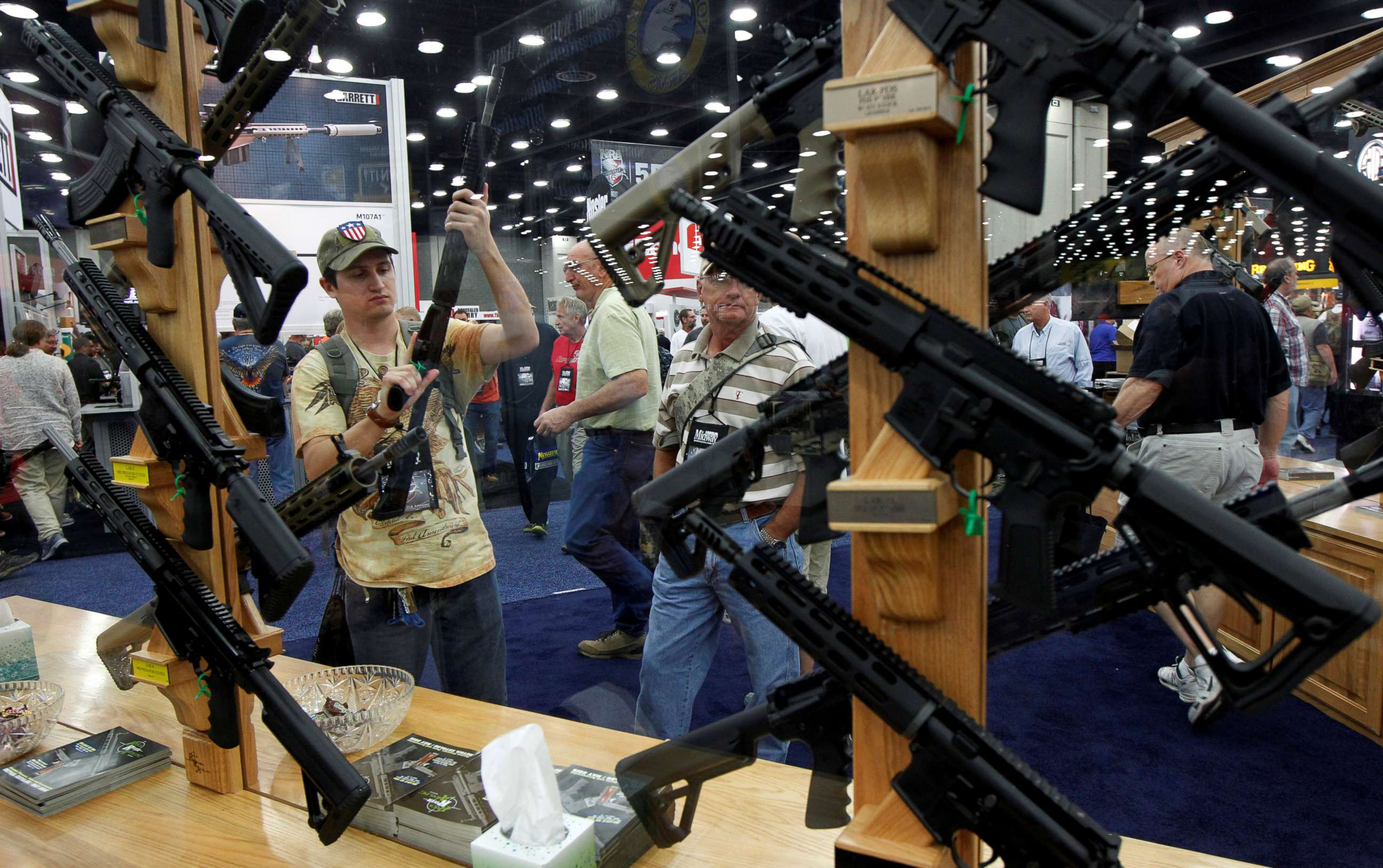 PHOTO: Gun enthusiasts look over Rock River Arms' guns at the National Rifle Association's (NRA) annual meetings and exhibits show in Louisville, Kentucky, May 21, 2016.