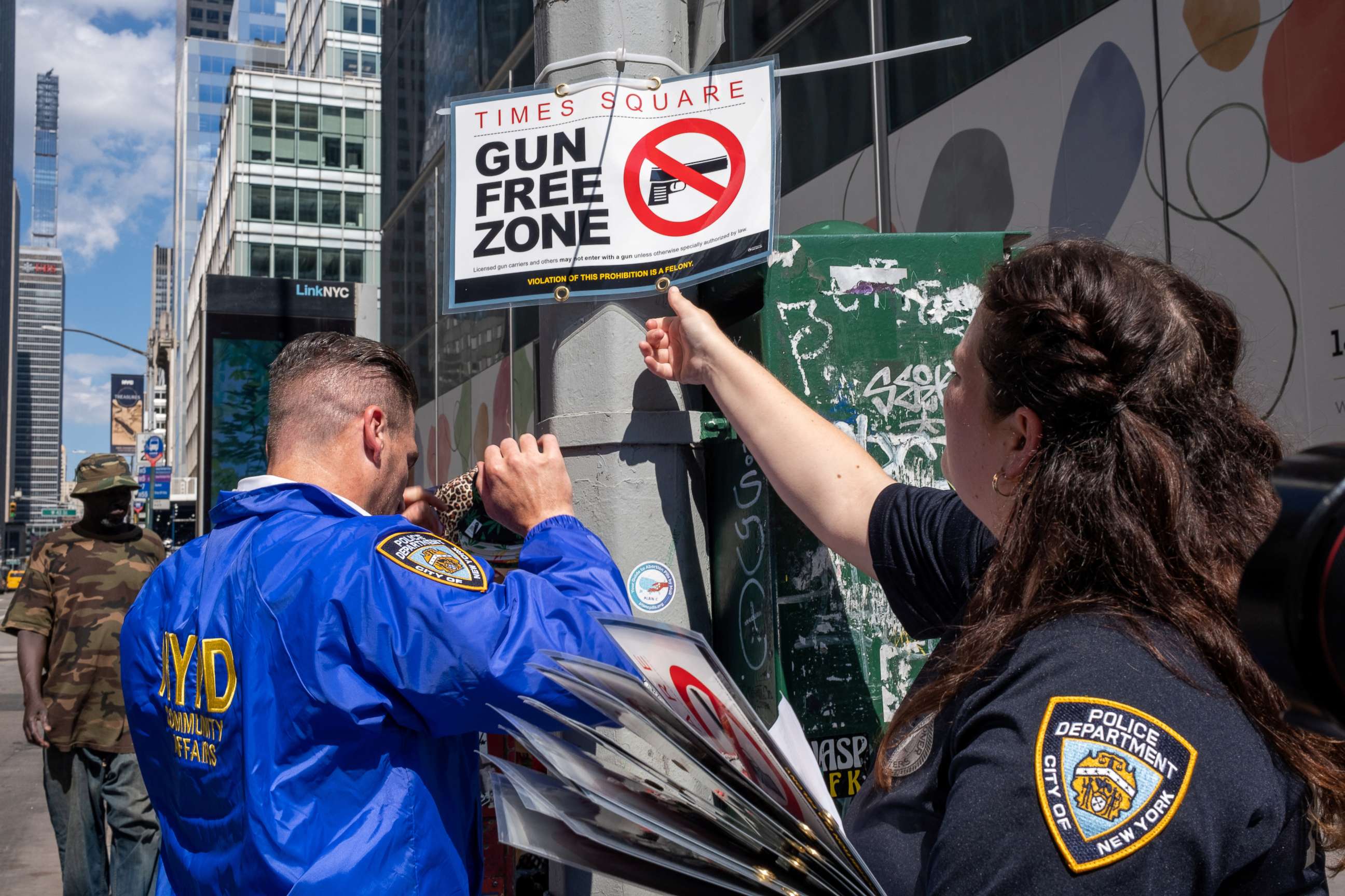 PHOTO: New York City police officers instal signs that read "gun free zone" at Times Square as new gun laws are due to come into effect, in New York, Aug. 31, 2022.