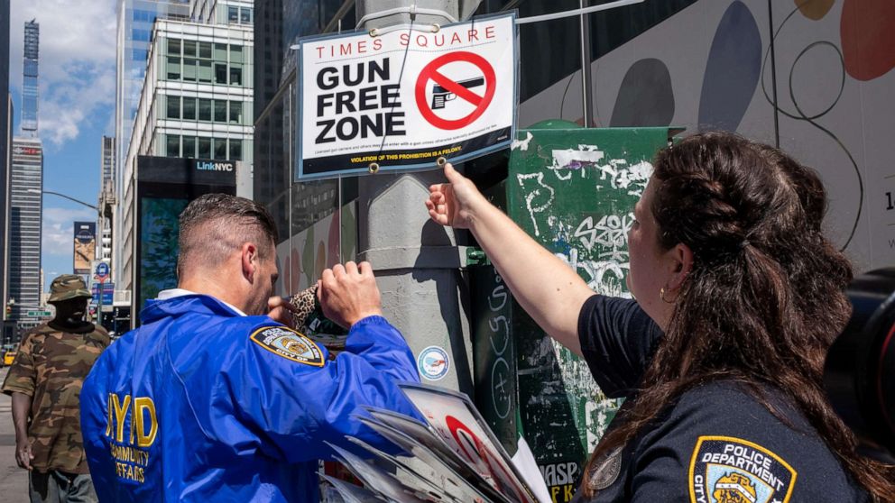 PHOTO: New York City police officers instal signs that read "gun free zone" at Times Square as new gun laws are due to come into effect, in New York, Aug. 31, 2022.