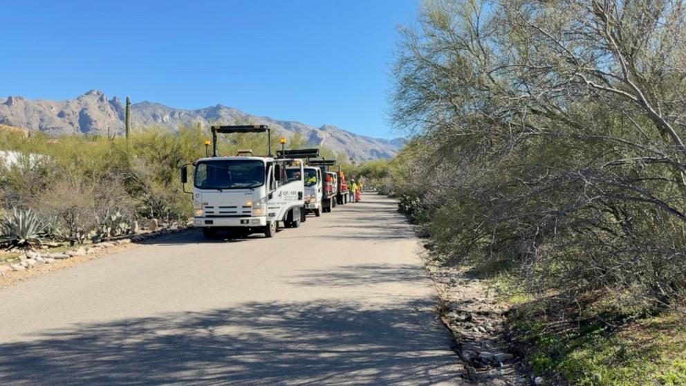 PHOTO: Work crews put up traffic barriers near the home of Nancy Guthrie.
 